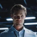 Portrait of handsome smiling it specialist using tablet computer in data center, looking at camera. succesful male e business engineer working in big server farm cloud computing facility.